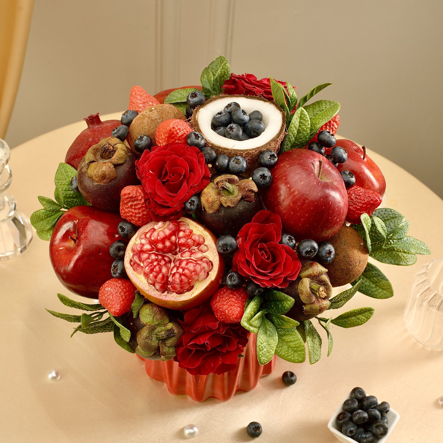 Fruit and flower arrangement on a beige surface