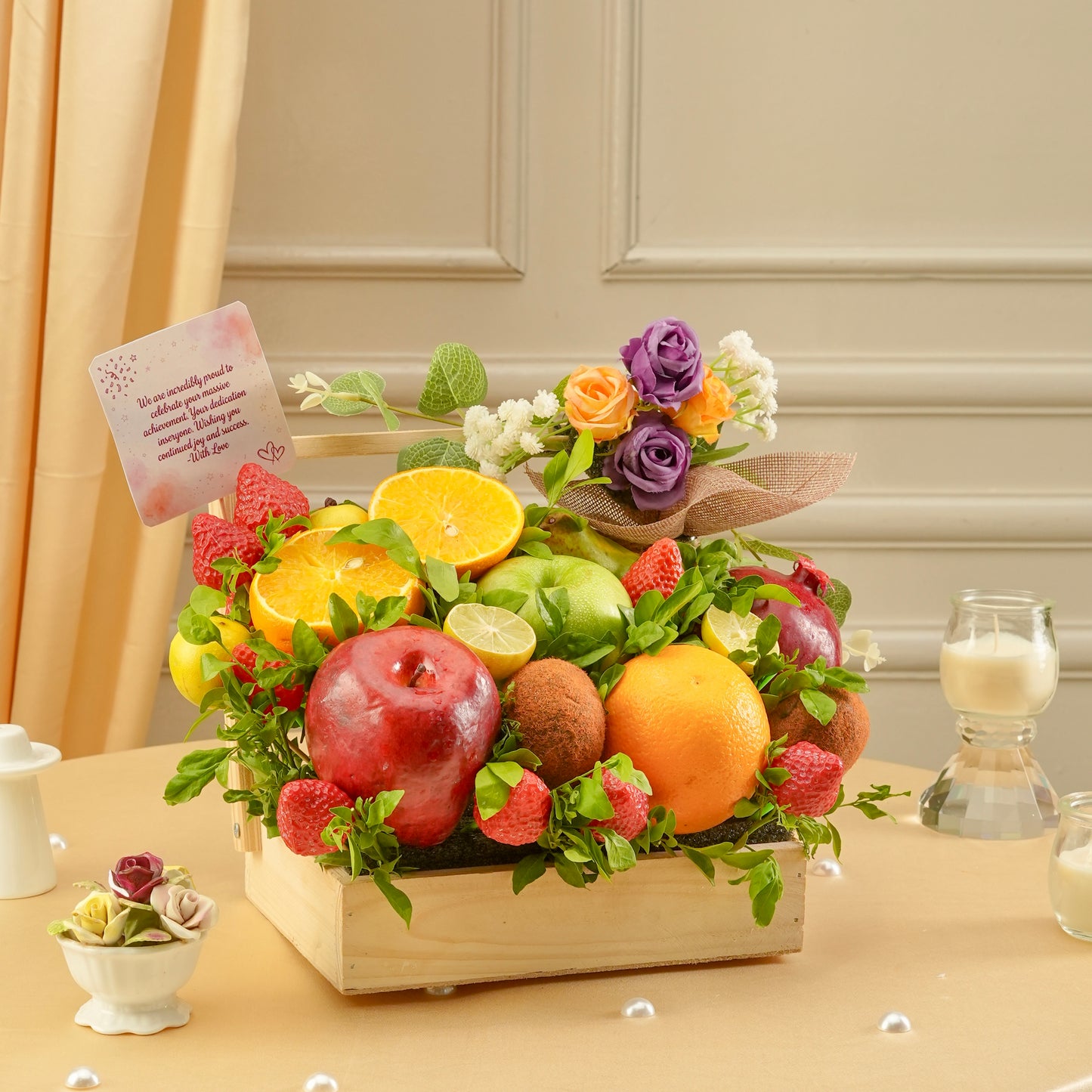 Fruit and flower arrangement in a wooden box on a table with a neutral background