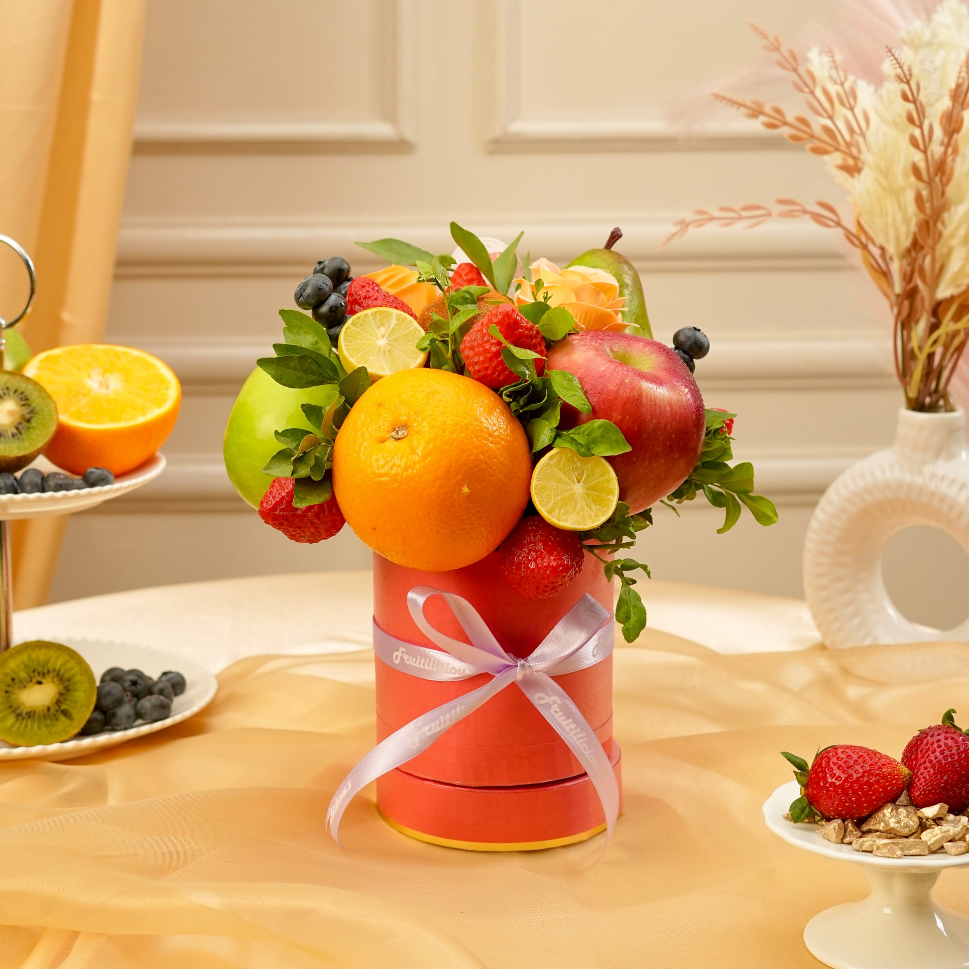 Fruit arrangement in a decorative box on a table with a neutral background