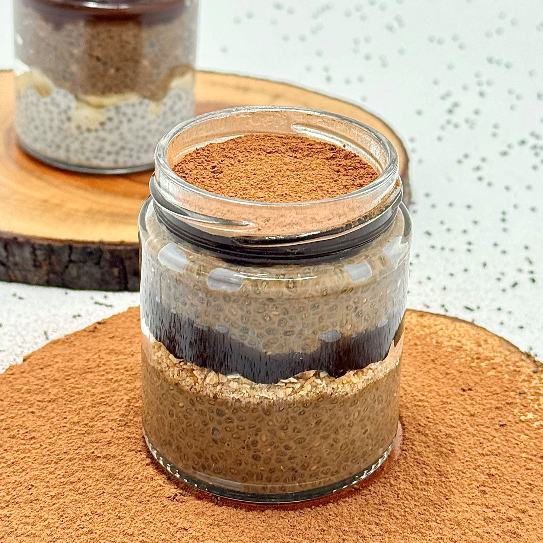 Layered dessert in a glass jar on a wooden surface