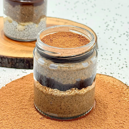 Layered dessert in a glass jar on a wooden surface