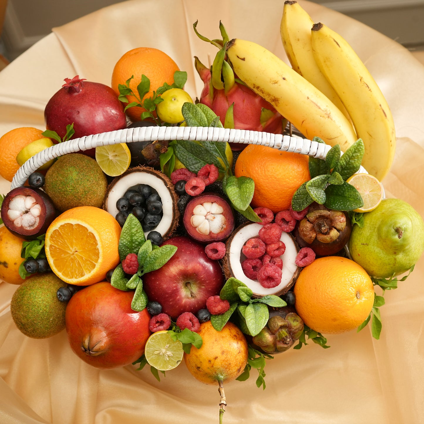 Assorted fruits arranged in a decorative manner on a beige fabric background