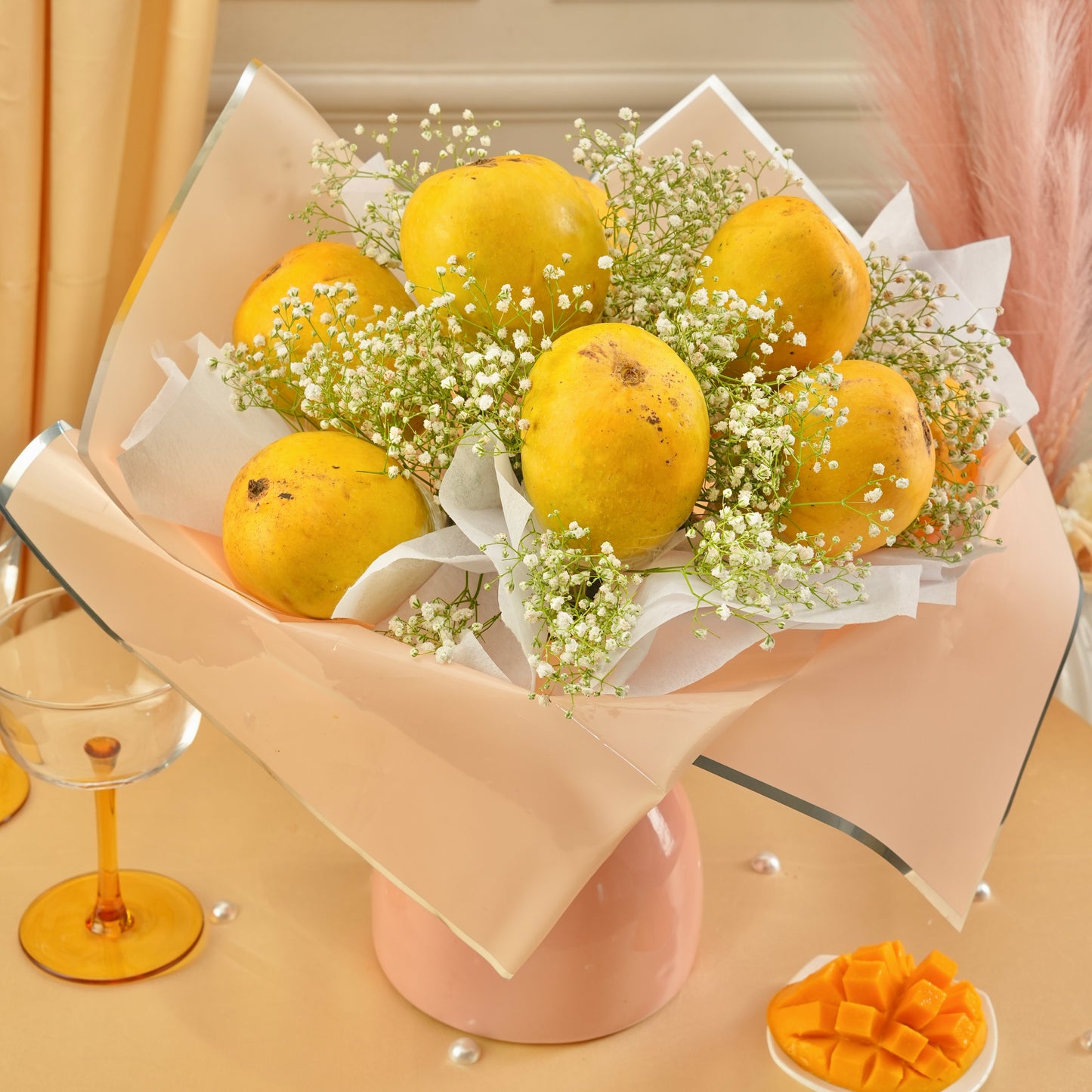 Elegant Mango Blossom gifting bouquet made with fresh juicy mangoes, baby’s breath flowers, and luxury pastel packaging.